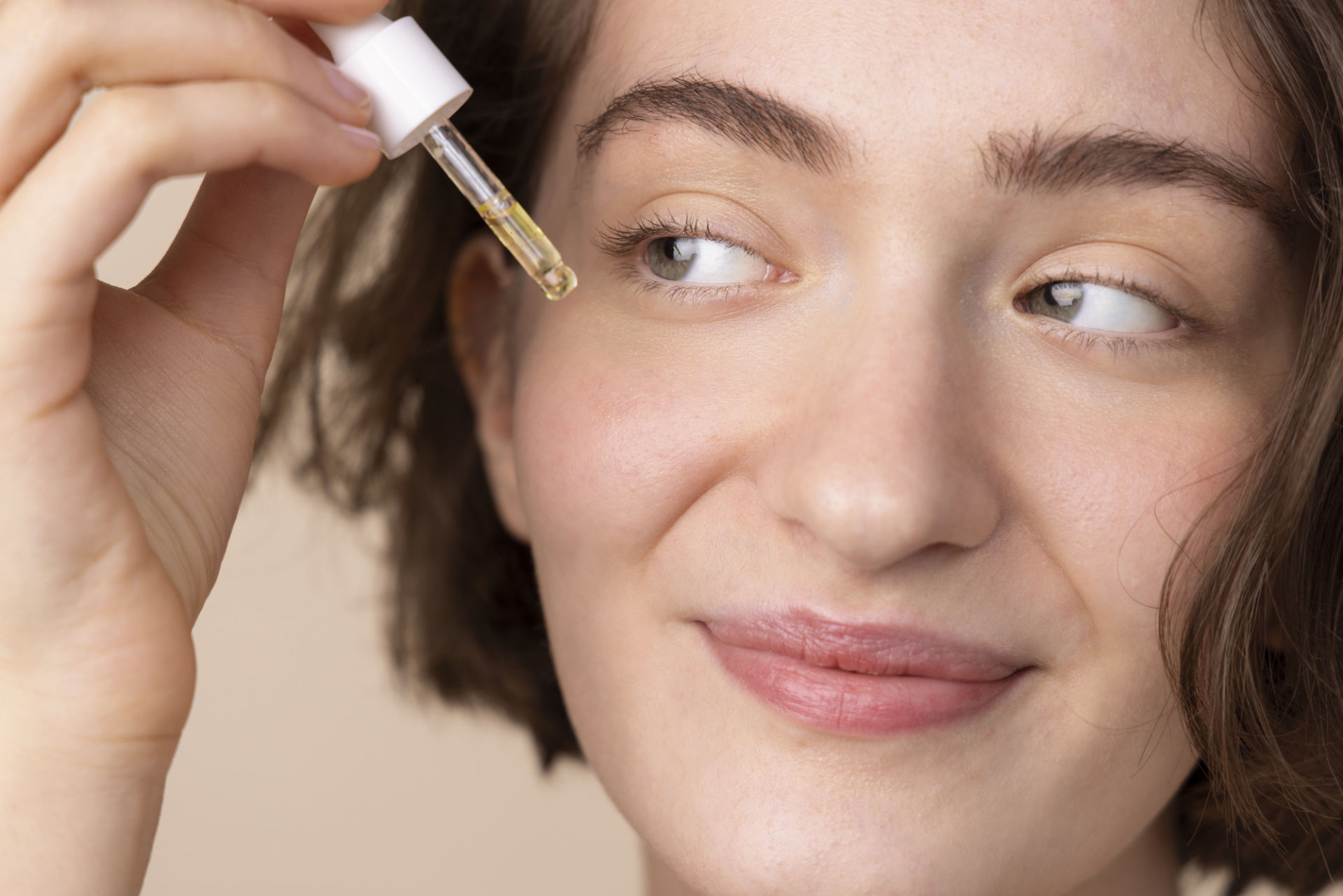 close-up-smiley-girl-using-face-serum-1