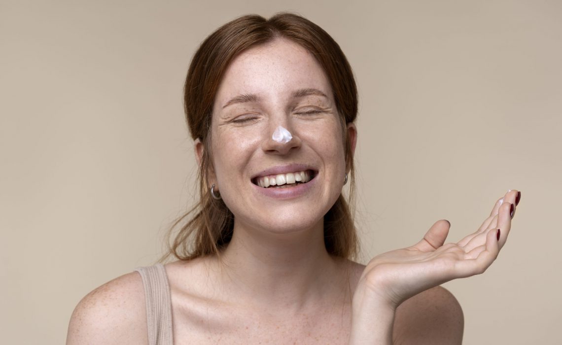 portrait-young-woman-applying-moisturizer-her-nose-1